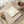 A stack of square cream-colored paper napkins featuring a watercolor-style floral wreath and a small white bunny on the top piece, shown on a clean white background.