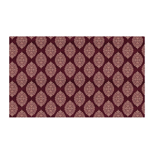 A rectangular area rug with a repeating damask pattern in burgundy and dusty rose, shown flat against a white background.