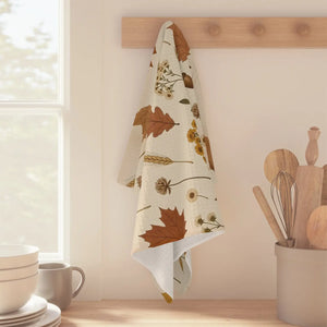 Hemmed cream kitchen towel from DipaliZ with a dried bloom motif