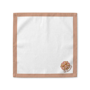 A square white cloth napkin with a tan border and a small gingerbread man graphic with text in the bottom right corner, displayed flat against a white background.