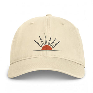 A beige baseball cap featuring a minimalist embroidered sun design on the front, set against a clean white background.