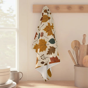 Hemmed cream tea towel from DipaliZ printed with autumn foliage