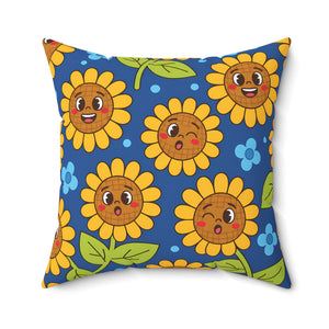 A square throw pillow featuring a playful cartoon sunflower pattern on a blue background. The sunflowers have expressive faces, with yellow petals, orange-brown centers, green leaves, and small blue flowers.