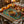 A rectangular decorative mat or placemat featuring a festive Diwali-themed mandala design with glowing oil lamps, garlands, and ornate floral borders on a dark teal background.