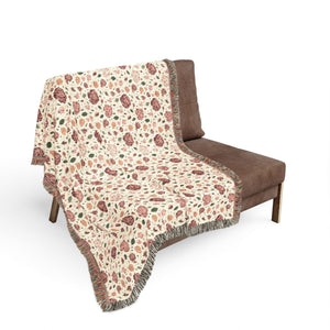 Decorative blanket with rose flowers design draped over a chair.