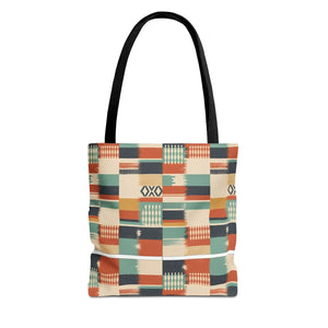A tote bag with a colorful geometric patchwork pattern in orange, teal, beige, and navy, featuring black shoulder straps, shown against a plain white background.