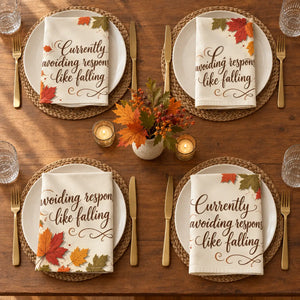 Amber and dull green leaf clusters at opposite corners of a DipaliZ cloth napkin