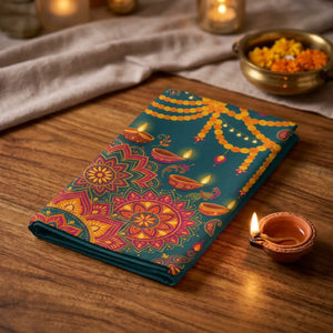 A square decorative textile or wall hanging featuring a festive Diwali-inspired mandala design with orange marigold garlands, lit oil lamps, and a teal background.
