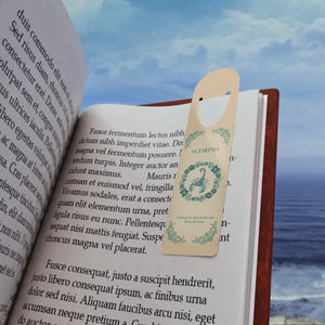Open book with a bookmark featuring an Aries symbol against a scenic background.