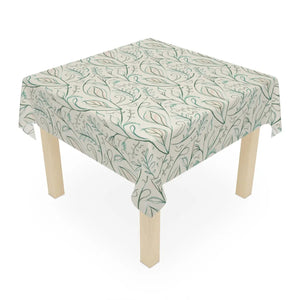 Spring foliage tablecloth by DipaliZ, green and gold leaves printed on a white polyester ground